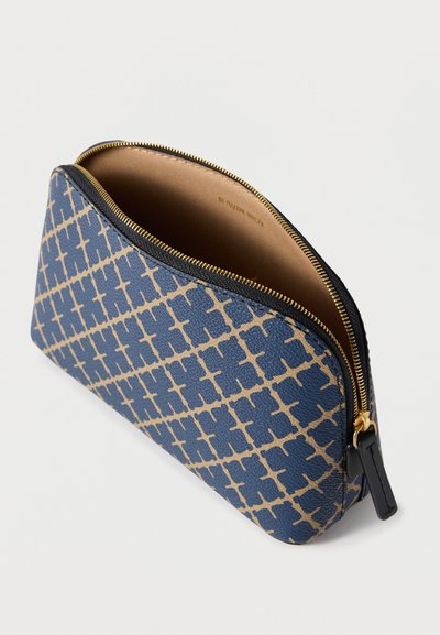 Μπλε υφασμάτινη θήκη με γεωμετρικό μπεζ σχέδιο, χρυστό φερμουάρ και μαύρες δερμάτινες λεπτομέρειες. Το εσωτερικό διαθέτει λείο, ανοιχτόχρωμο επένδυση.