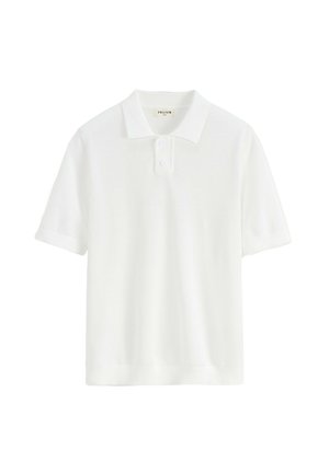 Polo shirt blanc à manches courtes en tissu texturé, avec un col classique, deux boutons, et des poignets et un ourlet côtelés.