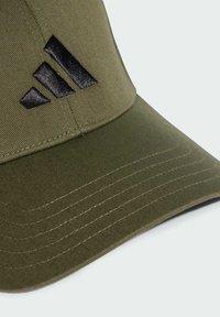 Olive green baseball cap made of fabric with a curved visor. Features a black textured three-stripe logo on the front panel.