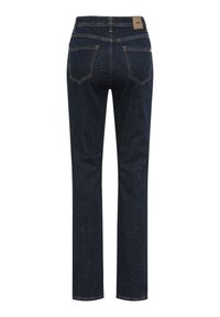 Jean en denim bleu foncé avec une coupe droite, dotés de poches arrière et d'une étiquette en cuir au niveau de la taille. Détails de surpiqûres en contraste.