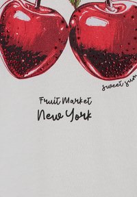 Tissu blanc présentant une illustration de deux pommes rouges brillantes avec des tiges vertes, embellies de paillettes, au-dessus du texte "Marché de Fruits New York."