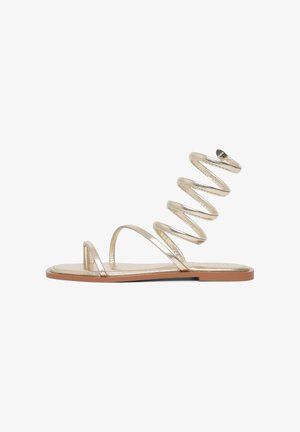 Goldene metallic Hohenabsatzsandalen mit einem Spiralbanddesign und flacher Sohle. Verfügt über dünne, minimalistische Riemen für ein elegantes Aussehen.