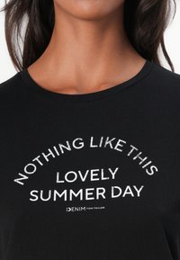 Tricou negru cu text alb îndrăzneț care spune "NU EXISTĂ NIMIC CA ACEASTĂ ZI DE VARĂ MINUNATĂ" aranjat în formă de arc. Material din bumbac moale, design cu guler rotund.