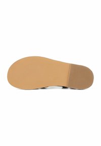 Suola della scarpa con una superficie di gomma beige liscia, strutturata per garantire aderenza, caratterizzata da una forma arrotondata e un tacco piatto.