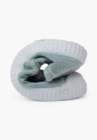 Zelená plátěná bota s bílou texturovanou gumovou podrážkou, spirálovým vzorem, prošitím a malou nálepkou na boku.