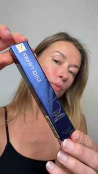 Estee Lauder Glossy Pout Lip Oil packaging in glossy navy blue with gold accents, rectangular shape, and product details on one side.
