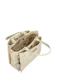 Bolsa tote perforada beige con asas verdes, herrajes plateados y un interior colorido con patrón. Presenta múltiples compartimentos y un acento de llavero.