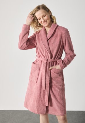 Pink terry bathrobe with a shawl collar, belt, and two front pockets. Soft texture, knee-length design, and casual fit.