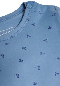 Ljusbl å bomulls-T-shirt med små marinblå blommönster, rundad halsringning och tryckknappdetalj på axeln.