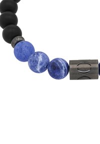 Perline nere opache alternate a perline blu tonde, che evidenziano texture diverse. Un accento metallico presenta un design ritagliato, accrescendo l'interesse visivo.