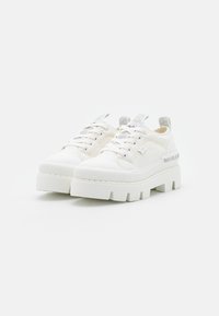 Białe sneakersy na platformie z gładką tkaniną na cholewce, teksturowaną gumową podeszwą i sznurówkami. Posiadają logo na boku oraz pętelkę do zakładania.
