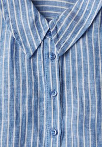 Hellblau gestreiftes Hemd aus strukturiertem Stoff. Verfügt über einen Kragen und eine Knopfleiste mit hellblauen Knöpfen.