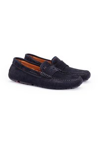 Marineblå ruskindsloafers med en syet design, struktureret overdel og flad gummisål. Indvendigt har de en kontrasterende lys brun foring.