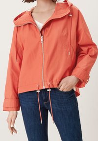Koralle Zip-Jacke mit Kapuze, Zugbandsaum und silbernen Beschlägen. Verfügt über ein leichtes Design und ein teilweise gefüttertes Innenfutter.