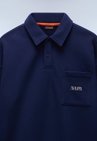 Πόλο μπλουζάκι σε ναυτικό μπλε χρώμα με γιακά, δύο κουμπιά, τσέπη στο στήθος και το λογότυπο "NAPA" κεντημένο με λευκά γράμματα στην τσέπη.