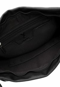 Wnętrze czarnej skórzanej torby z kieszonką na suwak, gładką podszewką i delikatnie teksturowanym wykończeniem. Posiada zamek błyskawiczny i minimalne logo.