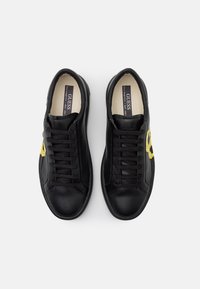 Black leather sneakers with a smooth texture, featuring yellow logo accents, round toe, and flat laces. Simple design and low-profile sole.