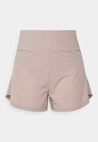 Pantalones cortos deportivos de mezcla de poliéster en color rosa claro, con una cinturilla ancha y aberturas laterales. Textura suave y detalle de costura limpia.