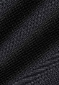Gros plan d'un tissu noir avec un motif de tissage carré serré et petit, montrant la texture et de subtiles réflexions de lumière.