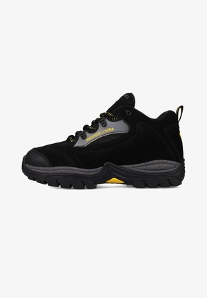 Svart ruskinn mid-top sneakers med gule detaljer, gummisåle, teksturert design og kontrasterende snøring. Logo på sidepanelet.