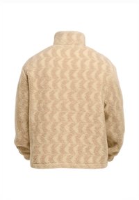 Beige fleece takki, jossa on aalto- kuvio, korkea kaulus ja rento leikkaus. Karhean pinnan omaava pehmeä materiaali, sopii rentoon käyttöön.
