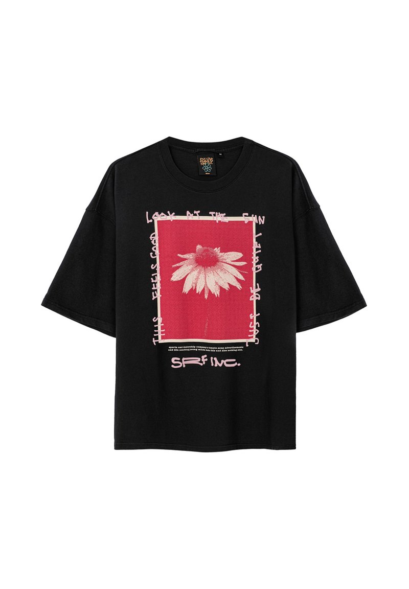 Czarna, oversize koszulka z grafiką przedstawiającą białą stokrotkę na czerwonym tle, otoczoną białym tekstem i różowymi ramkami.