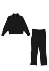 Tuta nera con giacca a zip e pantaloni coordinati. Presenta strisce bianche sui lati e polsini a coste. Realizzata in tessuto liscio.