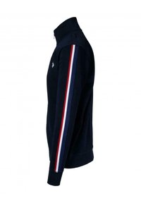Chaqueta de manga larga azul marino con rayas rojas, blancas y azules en las mangas y un pequeño logo bordado en el pecho.