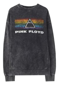 Sudadera negra de gran tamaño con cuello redondo y una textura desvaída. Presenta un gráfico de triángulo de arcoíris colorido y el texto "PINK FLOYD".