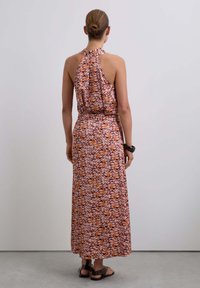 Vestido maxi con un alto cuello halter en un patrón abstracto de color rosa, naranja y púrpura; cuenta con una cintura elástica y espalda descubierta.
