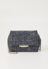 Handtasche aus navyblauem gewebtem Stoff mit einer metallischen Kettenriemen und einem metallischen Schild auf der Vorderseite; rechteckige Form und strukturierten Oberfläche.