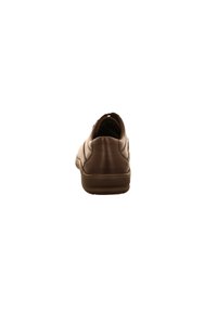 Sneaker en cuir marron avec un bout rond, texture lisse, profil bas et une semelle en caoutchouc. Présente des coutures simples sur le dessus.