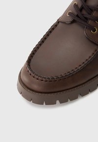 Brun læder sko med rund tå, syede detaljer og en struktureret gummisål med dybe riller for godt greb.