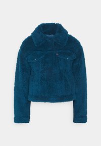 Faux fur-jacka i mörk teal, kort design med krage, två bröstfickor och långa ärmar med ribbade muddar. Strukturerad yta.