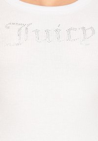 Top in cotone bianco a coste con la scritta "Juicy" in strass argentati. Il tessuto è morbido e presenta una silhouette aderente.