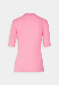 Haut ajusté rose à manches courtes avec texture côtelée, col classique et ourlet ajusté. Vue de dos montrant des lignes lisses et sans ornements.