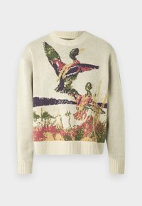 Pull en maille crème avec un motif multicolore de canards en vol sur un fond naturel. Col et poignets côtelés.