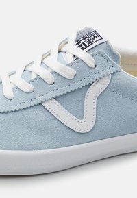 Light blue suede sneaker with white laces, a textured upper, rubber sole, and a white logo accent on the side.