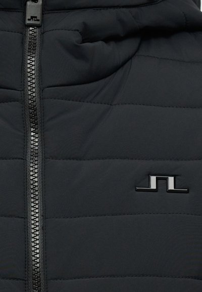 Μαύρο τμήμα κεντημένης ζακέτας με κεντρικό μαύρο φερμουάρ και μικρό μεταλλικό λογότυπο στη δεξιά πλευρά.