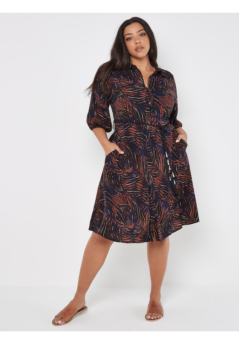 Schwarzes Kleid mit wirbelnden orangefarbenen und blauen Mustern, Knopfleiste, drei Viertel-Ärmel und Seitentaschen. Lässige Passform mit einem Gürtel in der Taille.