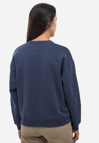 Sweat-shirt bleu marine avec un col rond et des manches longues. Présente une coupe décontractée et des poignets et un ourlet côtelés. Texture de tissu douce visible.