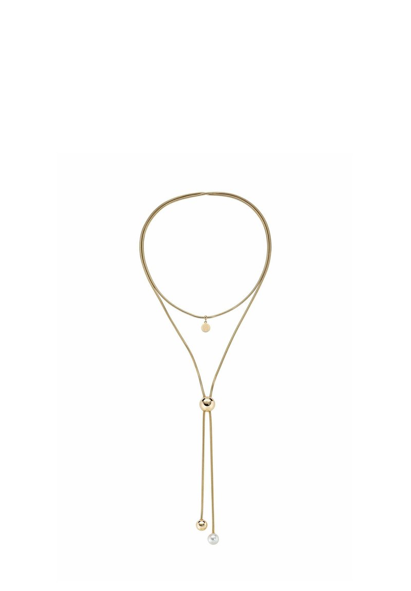 Zelta toņa kaklarota ar dubultslāņa dizainu, kurā ir apaļas bumbas akcents un neliels piekariņš. Gluda apdare ar minimālistisku estētiku.