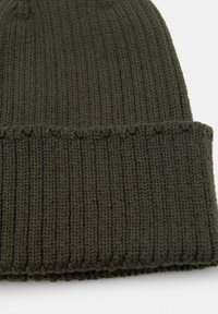 Pletena beživotna zimska kapa maslinaste boje s rebrastom teksturom i preklopljenim rubom. Tkanina je mekana i fleksibilna, s vidljivim detaljima šivanja.