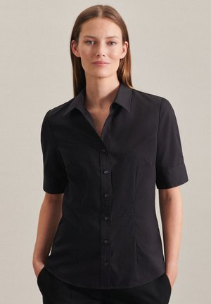 Camicetta nera a maniche corte con chiusura a bottoni, vestibilità su misura, colletto a punta e texture sottile. Presenta cuciture laterali per dare forma.
