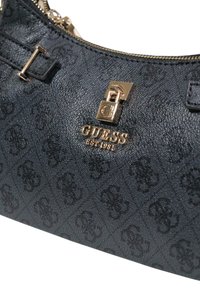 Bolso sintético negro con patrones de logo en relieve, herrajes dorados y cierre de cremallera. Presenta detalles con correas laterales y acabado texturizado.