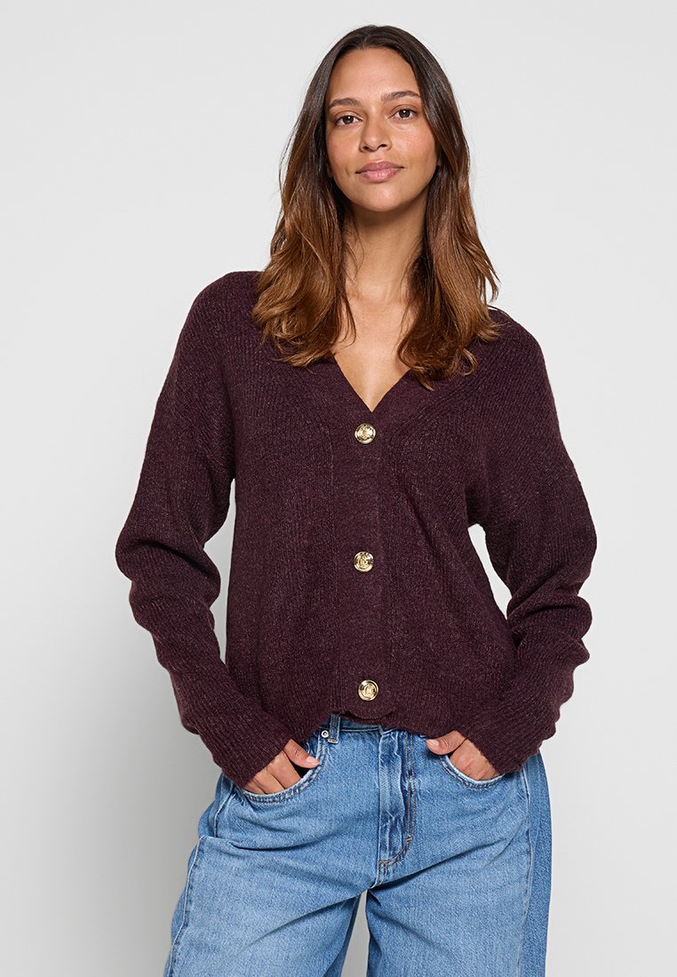 Bordeaux gebreide cardigan met een V-hals, lange mouwen en vijf goudkleurige knopen aan de voorkant. Textured stof en een relaxte pasvorm.