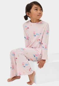 Helle rosa gerippte Schlafanzüge mit verspielten Mustern aus Blumen, Wolken und Comicfiguren; mit langen Ärmeln und weit geschnittenem Hosenbein.