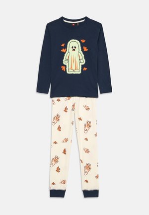 Pigiama per bambini in due pezzi, composto da una maglietta a maniche lunghe blu navy con una grafica di mostro e pantaloni crema con motivi di fantasmi arancioni e foglie.