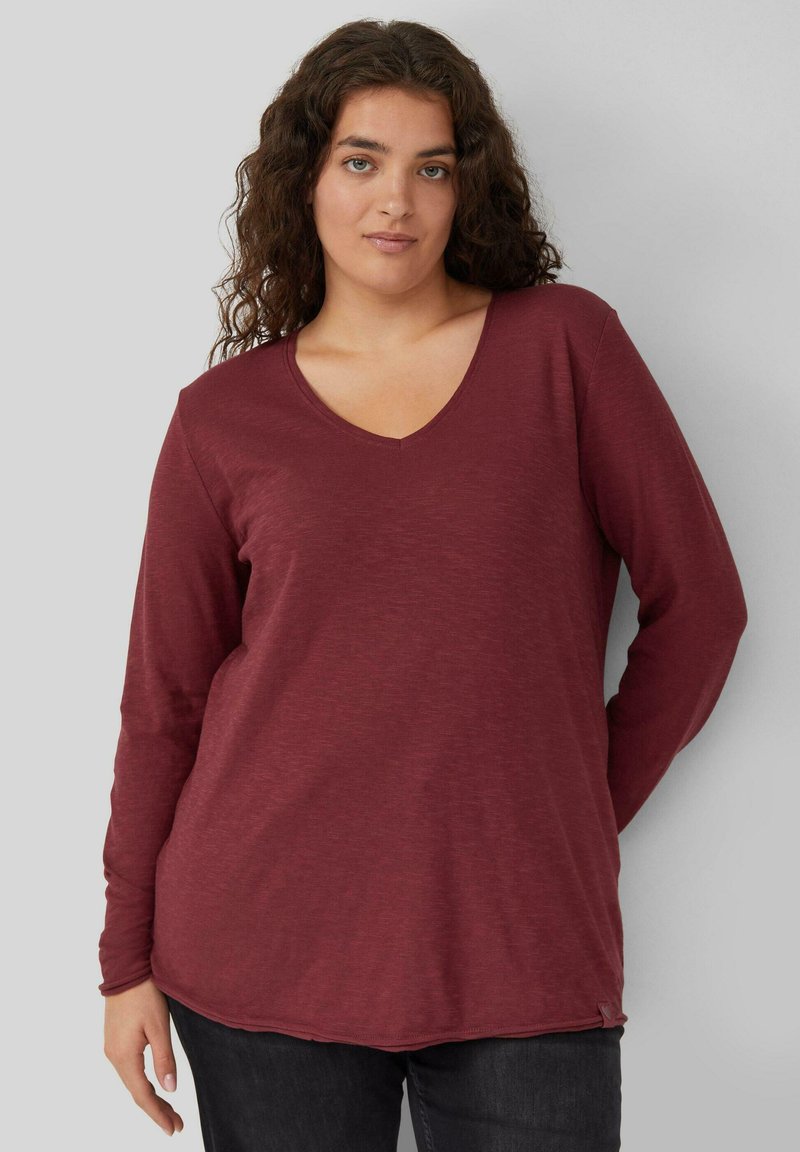 Burgunderfarbenes Langarm-V-Ausschnitt-Shirt mit lockerer Passform und weicher Textur, ausgestattet mit einem abgerundeten Saum und feiner Slub-Struktur.
