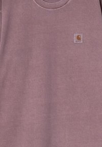 Fioletowa bawełniana bluza z okrągłym dekoltem oraz małą, kwadratową naszywką z logo Carhartt w lewym górnym rogu. Miękka tekstura.